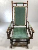 American rocking chair on original sprung base with turned supports and green velvet upholstery on