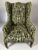 Elegant wing-backed upholstered arm chair on square tapering legs and ceramic castors