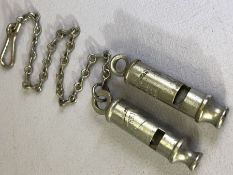 Two vintage Metropolitan Police whistles, one with chain, each approx 18cm in length