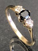 9ct Gold ring set with central faceted central stone and two illusion set diamonds to shoulders