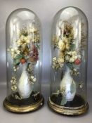 Pair of Victorian glass Parlour or display domes containing displays of dried flowers in vases, on