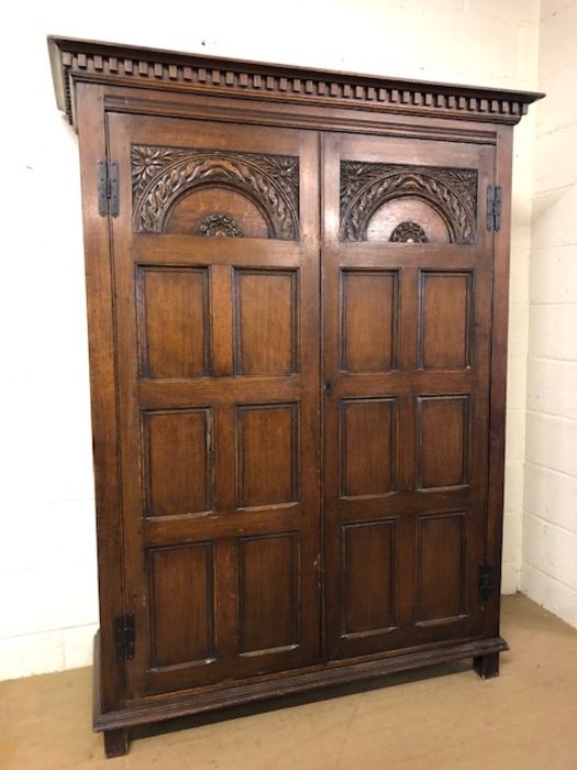 Two door oak wardrobe with carved detailing, approx 143cm x 58cm x 190cm tall