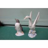 Lladro figure of a penguin and a Nao figure of an alighting swan