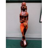 Carved figure of an African lady holding a flagon on oval plinth