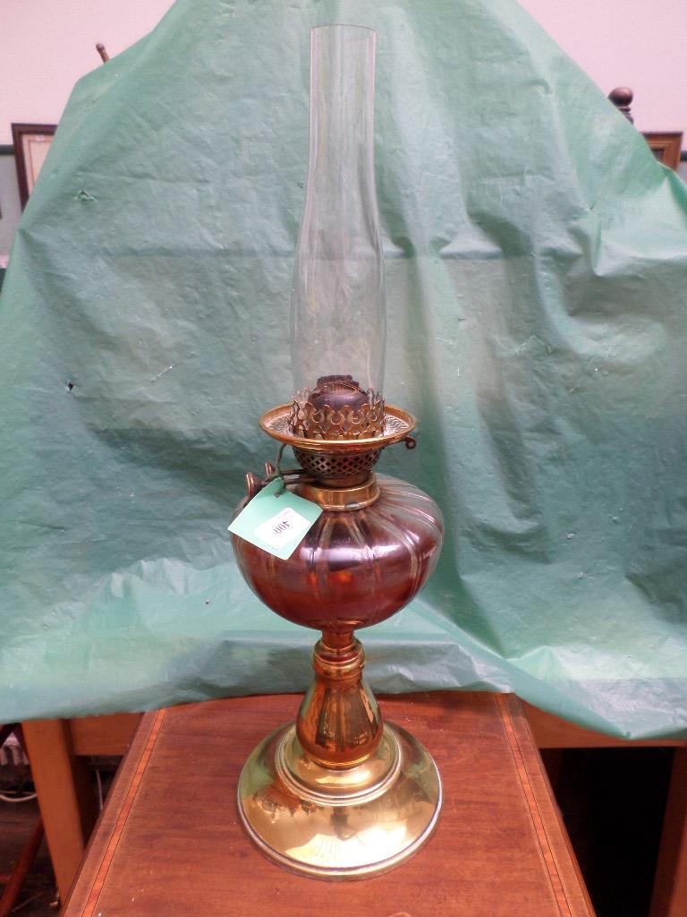 Brass oil lamp with glass chimney on circular brass base