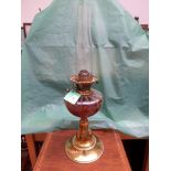 Brass oil lamp with glass chimney on circular brass base