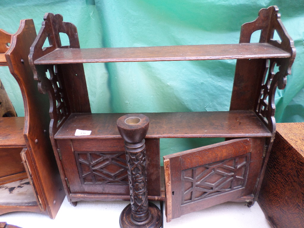 Small dark oak double shelf open display unit with double cupboard below together with a carved