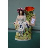 Flatback Victorian Staffordshire spell vase on oval plinth of bonneted country lady with rabbit in