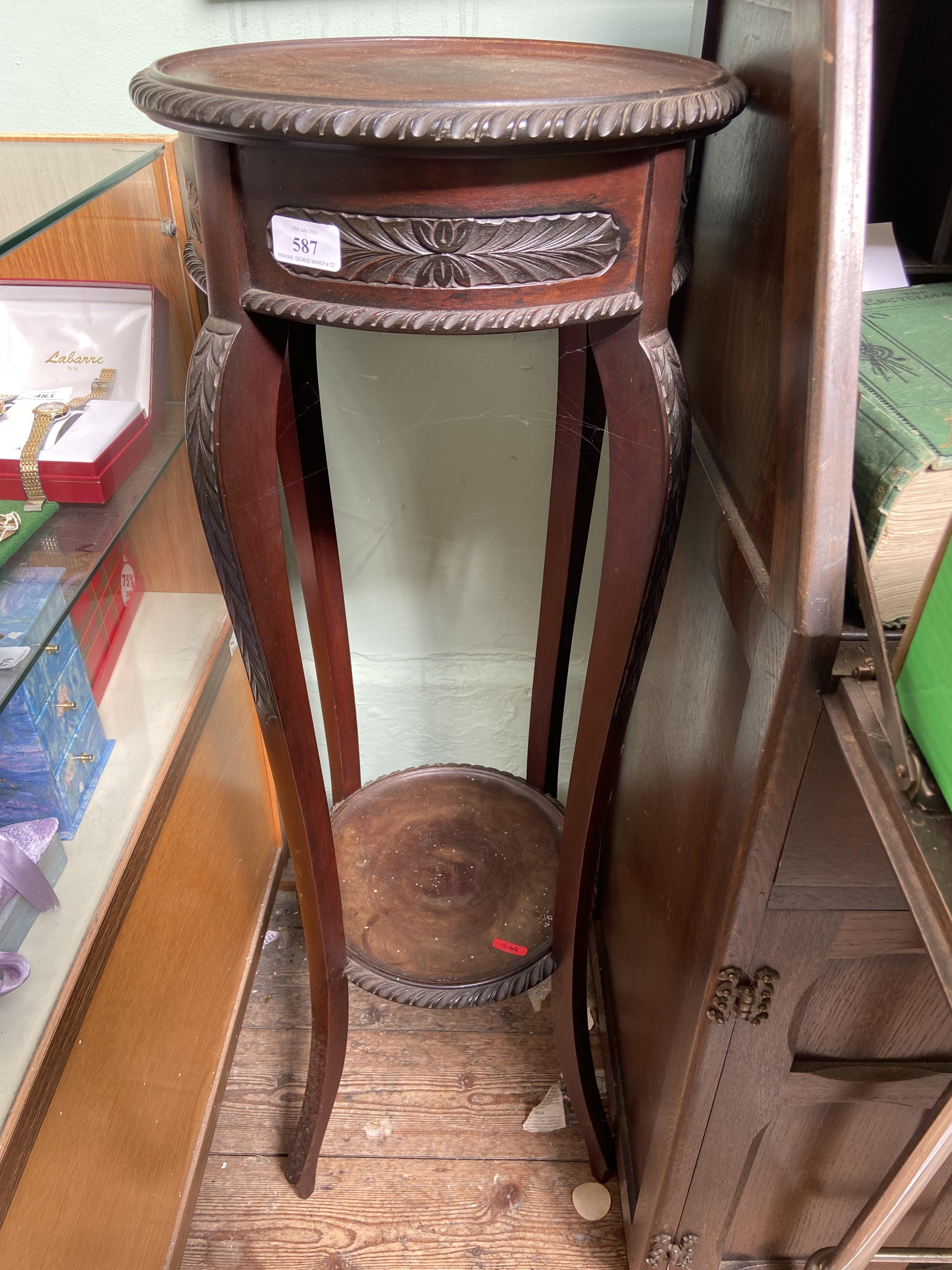 Carved circular topped plant stand with undershelf