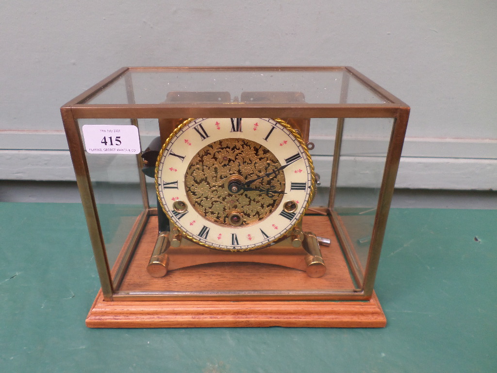 Unusual brass mantelclock with circular brass and light yellow enamel dial inset Roman Numerals all