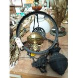 Brass ceiling light fitting with wrought iron surround and weight,