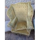 20th century fireside wing armchair on shaped spud feet upholstered in patterned gold fringed