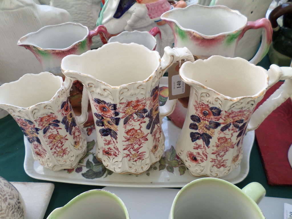 Set of three graduated jugs decorated richly multi coloured sprays and a further set of three - Image 2 of 3