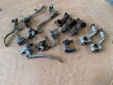 A quantity of carburettor air/choke levers and other levers, plus Douglas handlebar clamps.