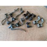 A quantity of carburettor air/choke levers and other levers, plus Douglas handlebar clamps.