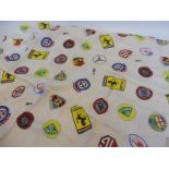 A Les Leston headscarf covered in classic car badges, folded.