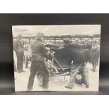 A large scale photographic print of Count 'Lou' Zborowski and friends stirring Chitty Bang Bang into