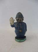 An unusual lead accessory mascot in the form of a policeman with one hand raised to stop traffic.
