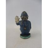 An unusual lead accessory mascot in the form of a policeman with one hand raised to stop traffic.