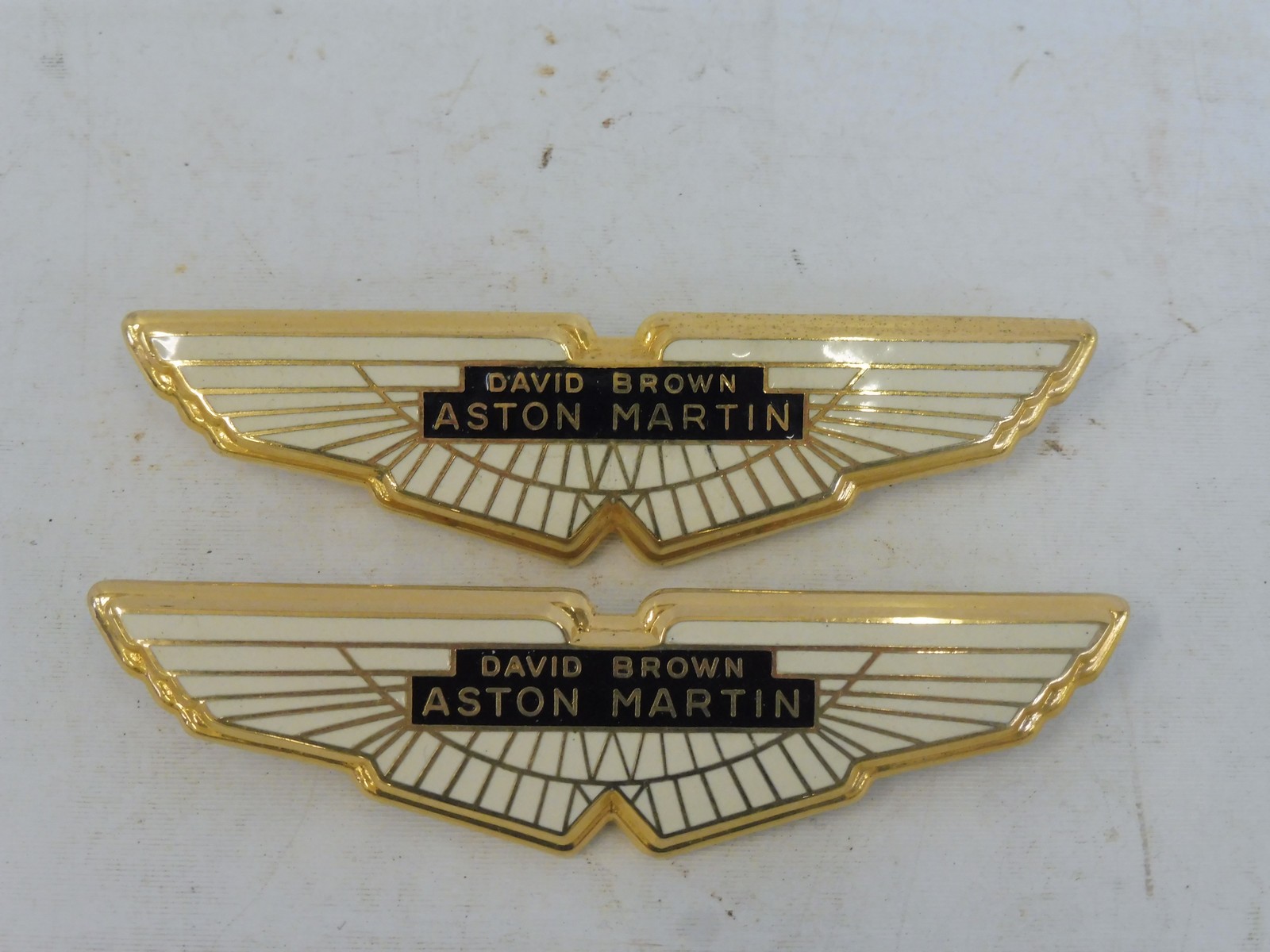 Two David Brown Aston Martin car badges.