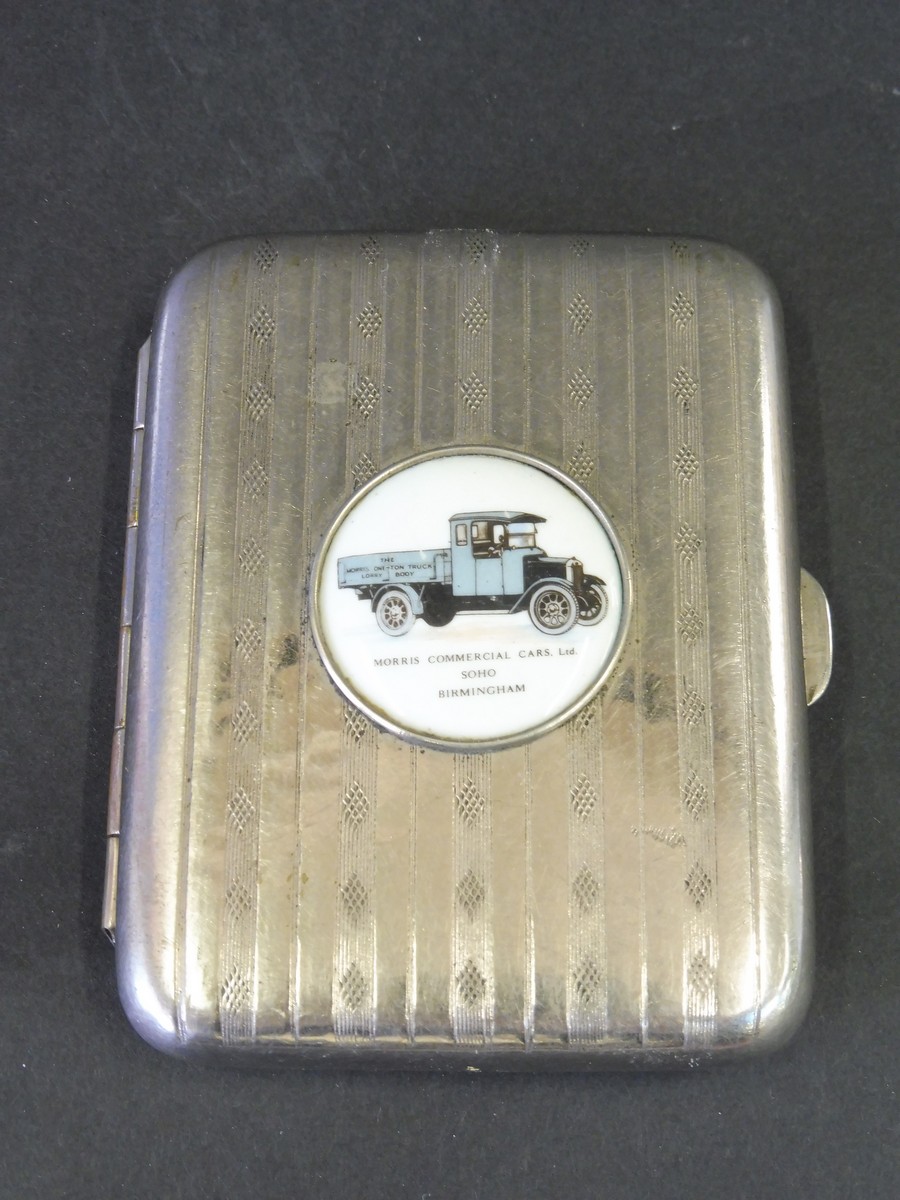 A Morris Commercial Cars silver plated cigarette case, the lid inset with a circular porcelain or