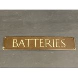 A small brown and cream coloured enamel sign for 'Batteries', 12 x 2 1/2".