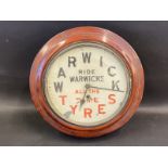 A Warwick Tyres circular wall clock.
