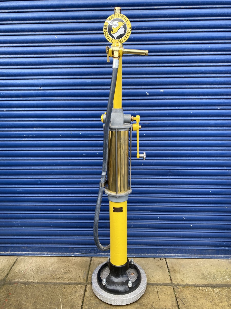 A Wayne skeleton petrol pump with rubber hose and polished brass nozzle, restored in National