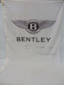 A large Bentley flag bearing hand-written text for 'Le Mans 2002 Mike & Graham 4th', 44 x 77 1/2".