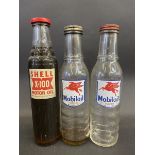 A Shell X-100 Motor Oil pint oil bottle and two Mobiloil pint oil bottles.