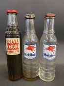 A Shell X-100 Motor Oil pint oil bottle and two Mobiloil pint oil bottles.