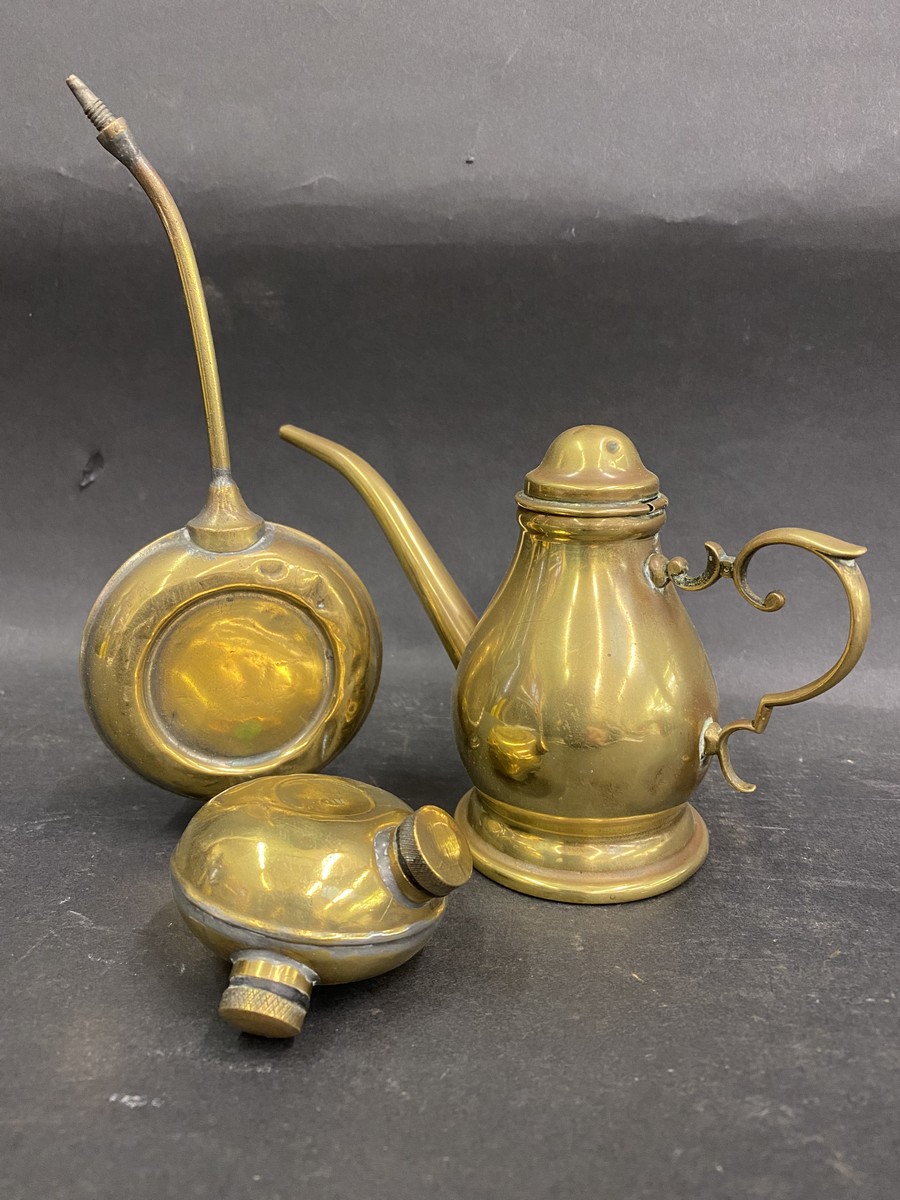 An Art Nouveau style polished brass oiler and two others.