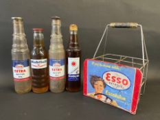Four pint oil bottles, comprising two Esso Extra, one Mobiloil and a Havoline, in a home made four