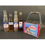 Four pint oil bottles, comprising two Esso Extra, one Mobiloil and a Havoline, in a home made four