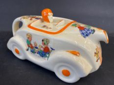 An Art Deco ceramic teapot in the form of a streamlined racing car decorated with nursery scenes.