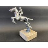 A Desmo car accessory mascot in the form of a horse and jockey jumping, display base mounted.