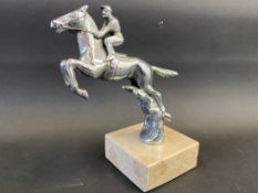 A Desmo car accessory mascot in the form of a horse and jockey jumping, display base mounted.