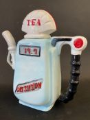 A decorative ceramic teapot in the shape of a petrol pump with globe.