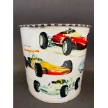 A waste paper bin decorated with Formula 1 race cars from the 1960s, 7" high.