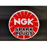 An NGK Spark Plugs circular embossed tin sign, 17 1/2" diameter.