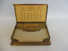 A Goodyear tyres advertising brass paper note holder and calendar.