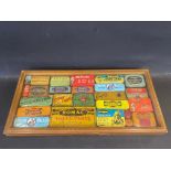 A collection of cycling/motoring tins in a glass topped display case.