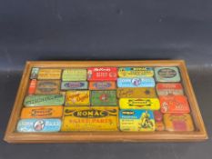 A collection of cycling/motoring tins in a glass topped display case.