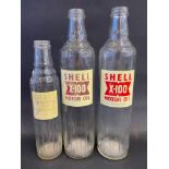 Two Shell X-100 quart glass oil bottles plus a pint version, two labels faded.