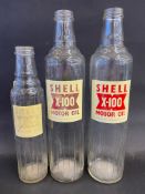 Two Shell X-100 quart glass oil bottles plus a pint version, two labels faded.