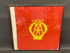 A framed and glazed red AA flag with yellow emblem to the centre, 27 1/2 x 26".