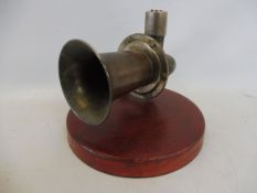A Cowey horn, mounted on a wooden base.