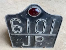 An aluminium number plate with integral lamp for reg. no. 6101 JP.