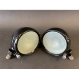 A small pair of sidelights, black enamel bodies and opaque lenses, appear fully restored,