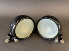 A small pair of sidelights, black enamel bodies and opaque lenses, appear fully restored,
